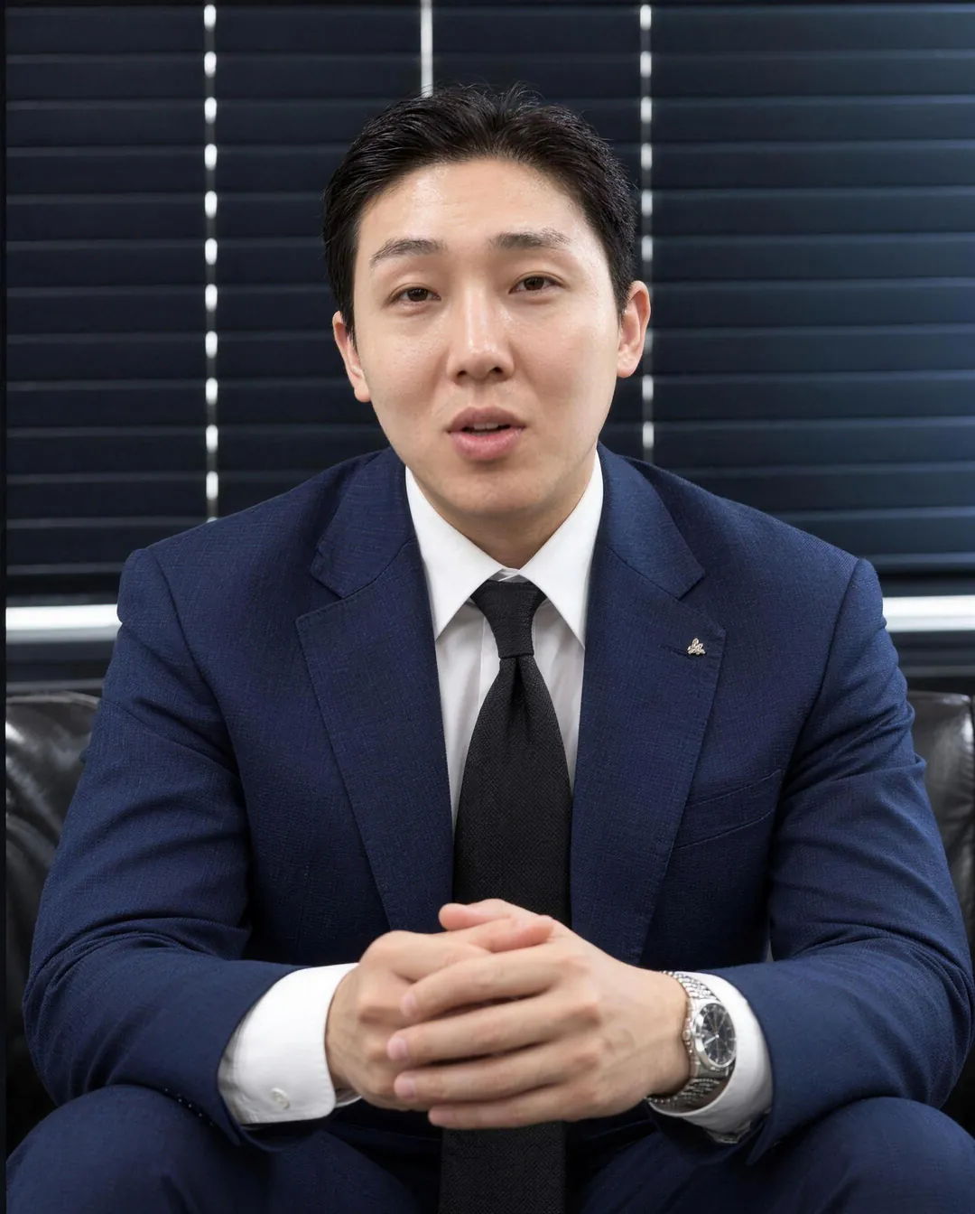 네이비 수트를 입고 인터뷰하는 백룡 이사